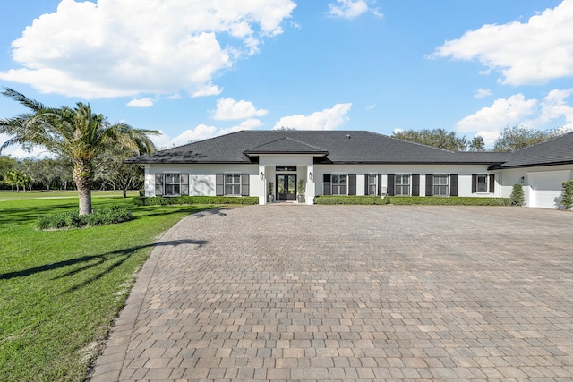 prairie-style house featuring a front lawn and a garage