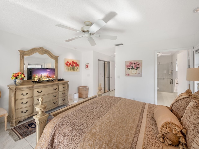 bedroom with ceiling fan, a textured ceiling, connected bathroom, light tile patterned flooring, and a closet