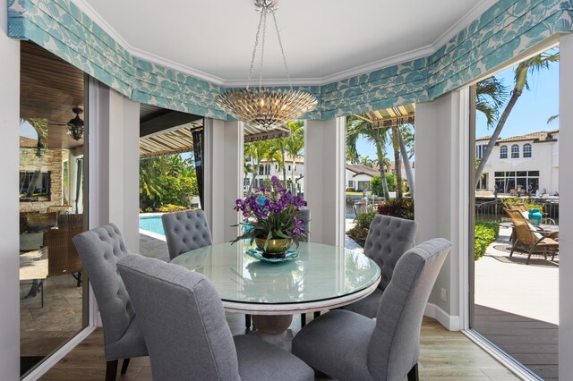 dining area featuring a notable chandelier, ornamental molding, and a wealth of natural light