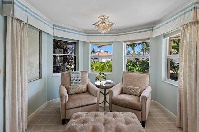 living area with a chandelier, a wealth of natural light, and ornamental molding