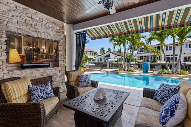 view of swimming pool with an outdoor living space with a fireplace, ceiling fan, and a patio area