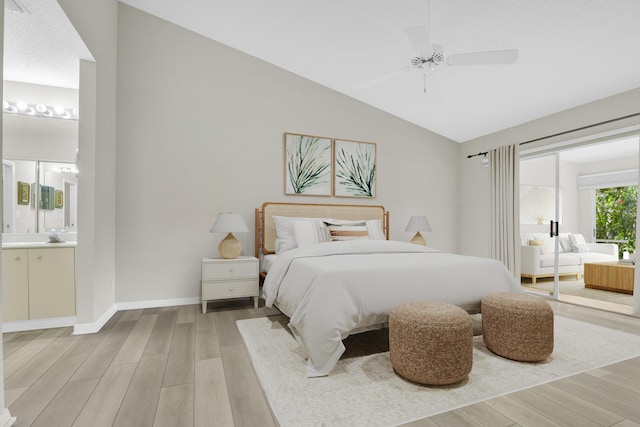 bedroom with ensuite bath, ceiling fan, wood-type flooring, and vaulted ceiling