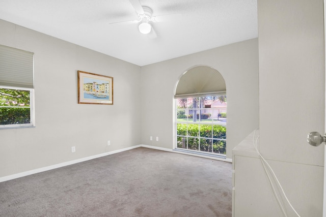 carpeted spare room with ceiling fan