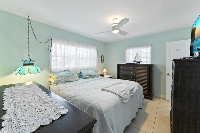 tiled bedroom featuring ensuite bath, ceiling fan, and a closet