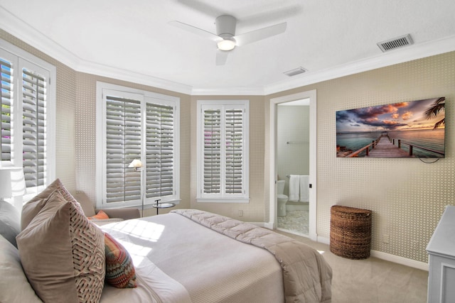 bedroom with ornamental molding, connected bathroom, light colored carpet, and ceiling fan