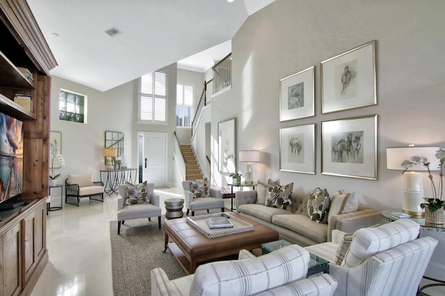 living room featuring light tile patterned floors and a towering ceiling