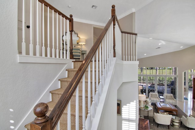 staircase featuring crown molding and a high ceiling