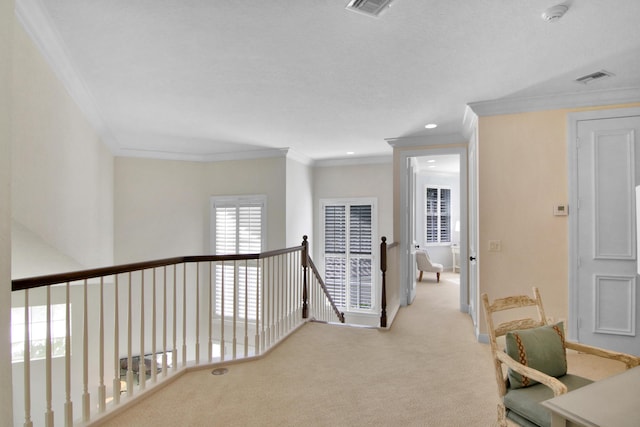 hall with ornamental molding and light colored carpet