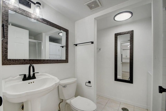 bathroom with tile patterned flooring, toilet, a shower with shower door, and sink