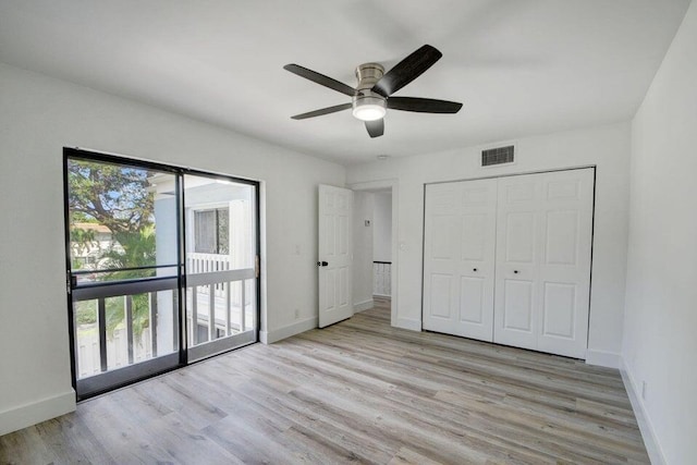 unfurnished bedroom featuring multiple windows, light hardwood / wood-style flooring, a closet, and ceiling fan