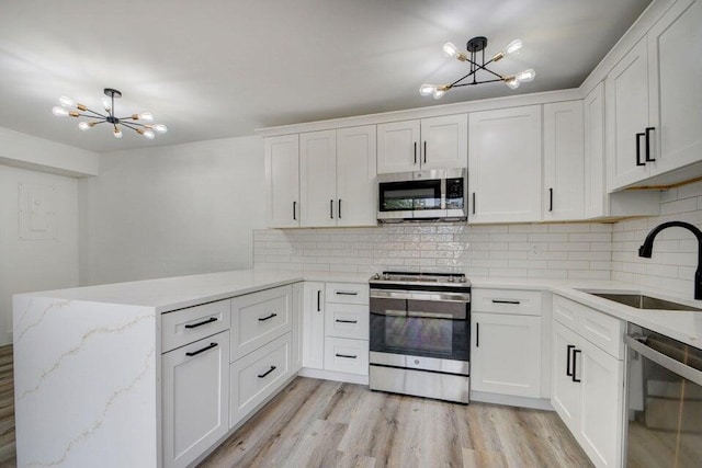 kitchen featuring stainless steel appliances, white cabinetry, and sink