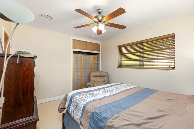 bedroom with ceiling fan, a closet, and light tile patterned flooring