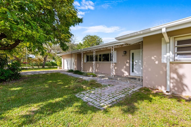 entrance to property featuring a yard and a garage