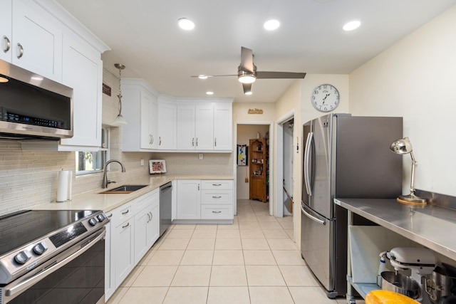 kitchen featuring appliances with stainless steel finishes, ceiling fan, sink, decorative light fixtures, and white cabinetry