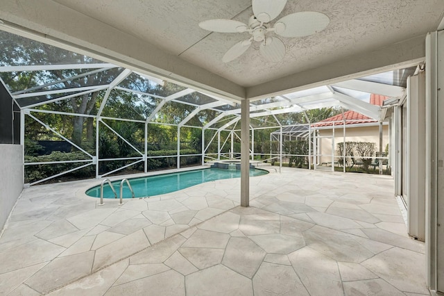 view of pool with a lanai, ceiling fan, a patio, and an in ground hot tub