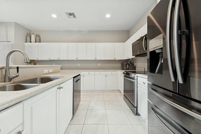 kitchen with light tile patterned floors, stainless steel appliances, white cabinetry, and sink