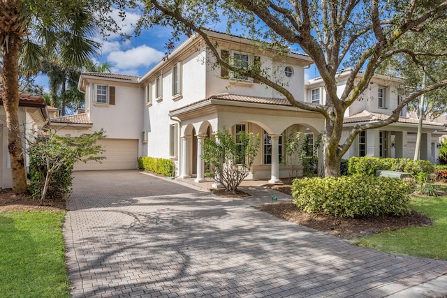 mediterranean / spanish house featuring a porch and a garage