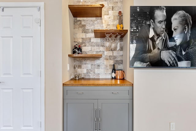 bar featuring backsplash and gray cabinets