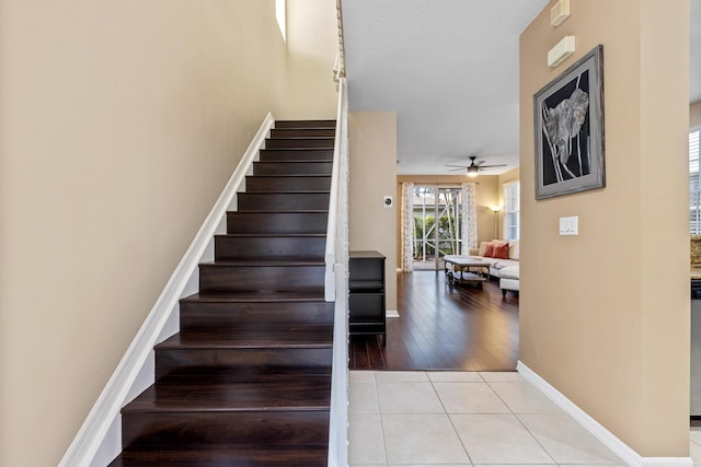 stairs featuring tile patterned floors and ceiling fan