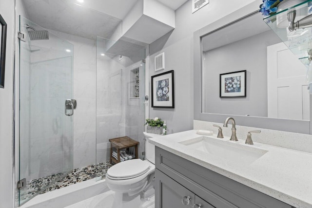 bathroom featuring a shower stall, visible vents, vanity, and toilet