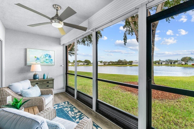 sunroom with a water view and ceiling fan