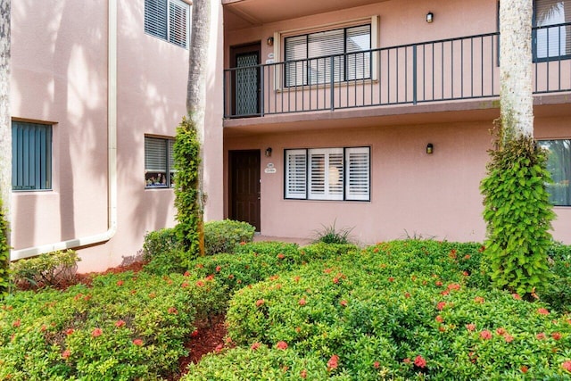 doorway to property featuring a balcony and stucco siding