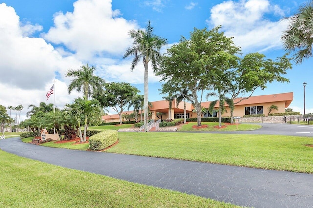 surrounding community featuring a yard, aphalt driveway, and fence