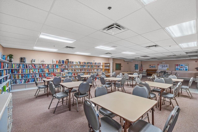 carpeted dining space featuring visible vents and a drop ceiling