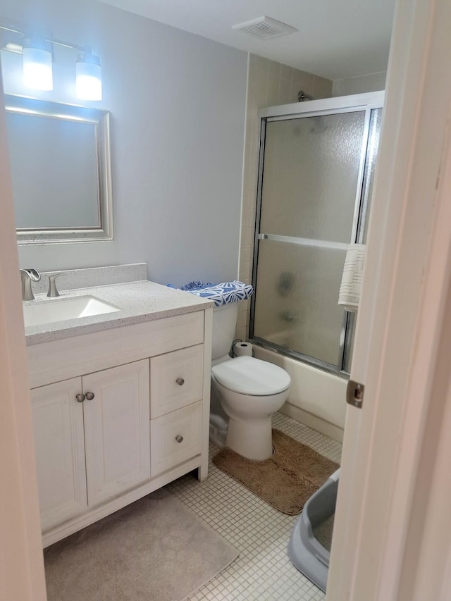 full bathroom with combined bath / shower with glass door, vanity, and toilet