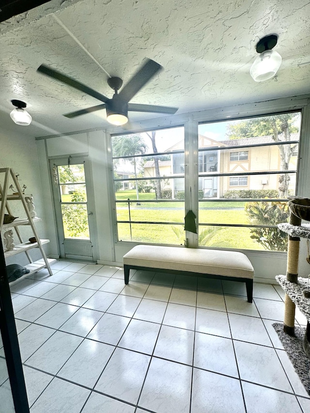 unfurnished sunroom with ceiling fan