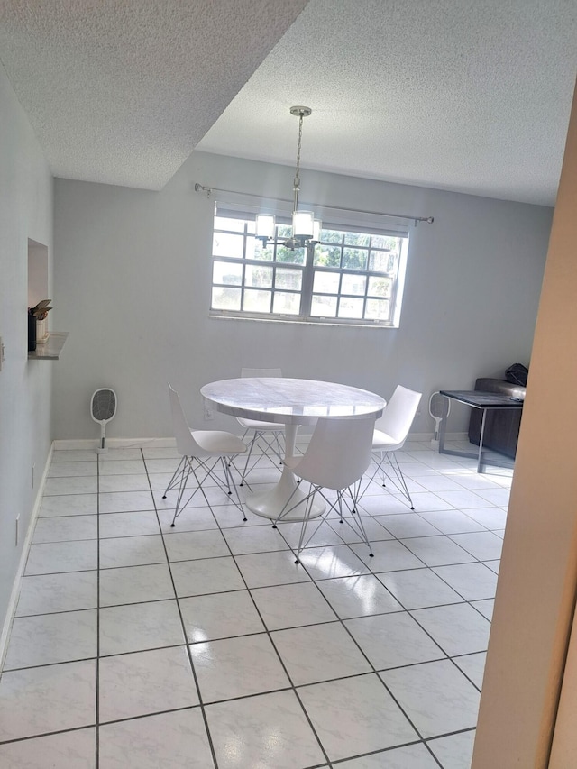 tiled dining space with a chandelier and a textured ceiling