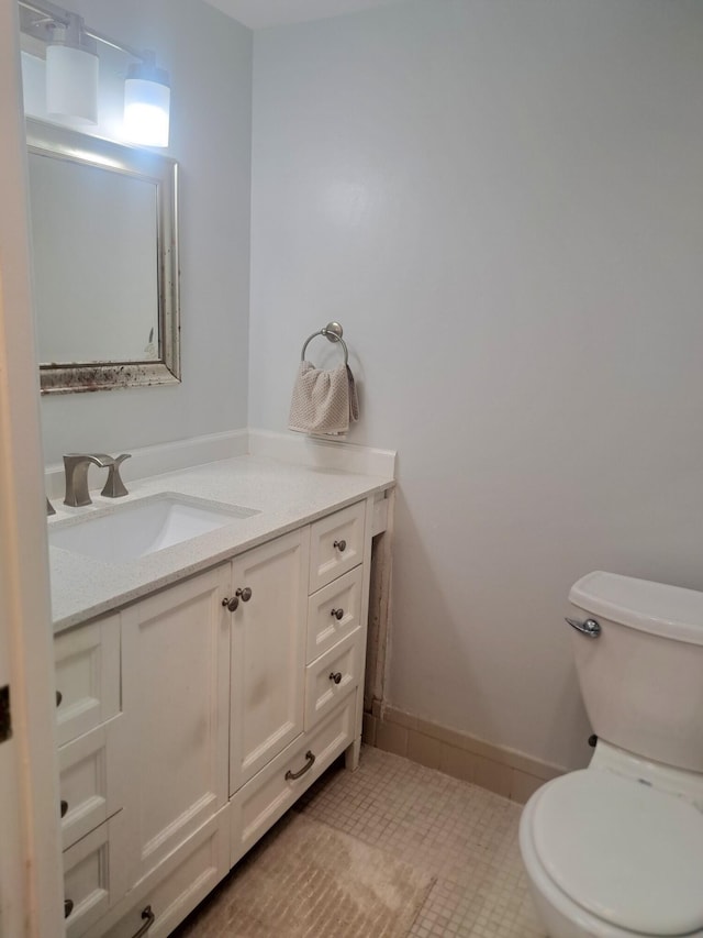 bathroom with toilet, tile patterned floors, and vanity