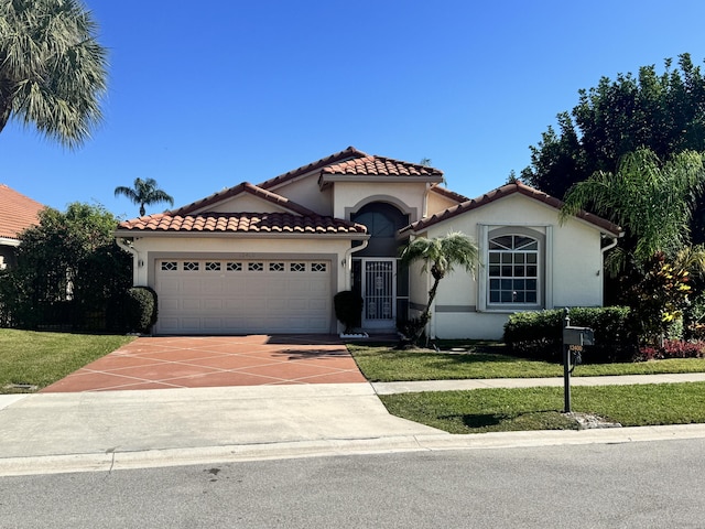 mediterranean / spanish house with a garage and a front yard