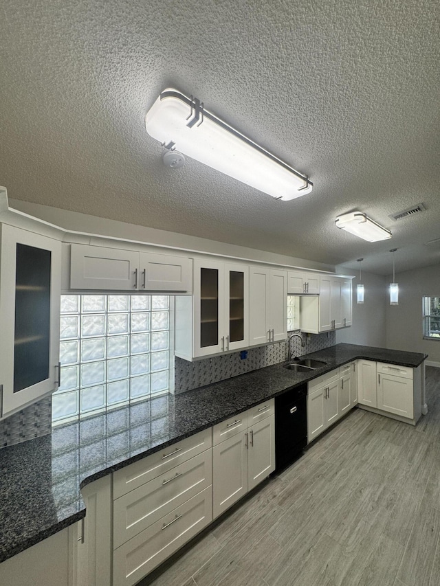 kitchen featuring sink, white cabinets, dark stone counters, and light hardwood / wood-style flooring