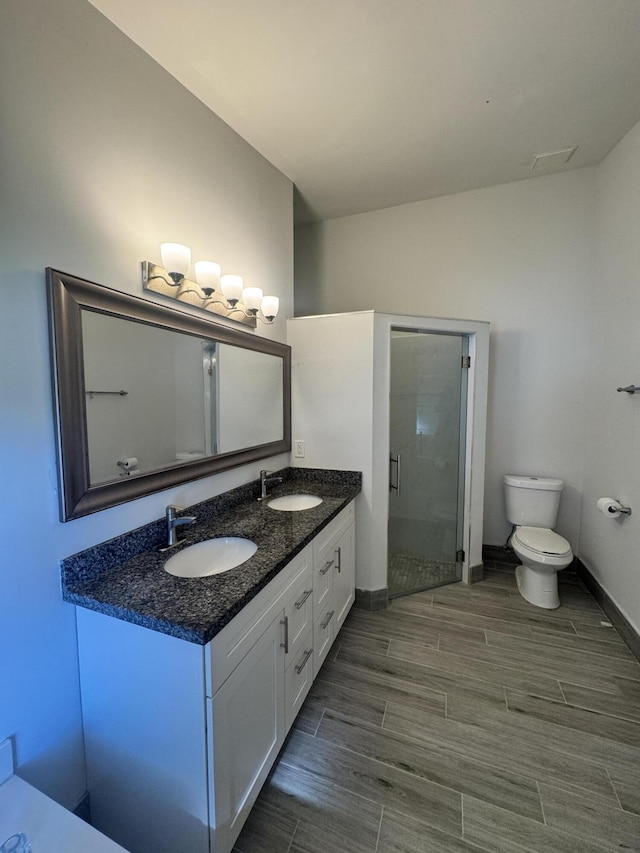 bathroom featuring vanity, toilet, and an enclosed shower