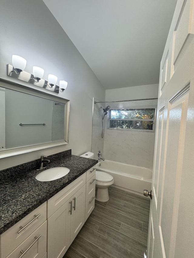 full bathroom featuring vanity, tiled shower / bath combo, and toilet