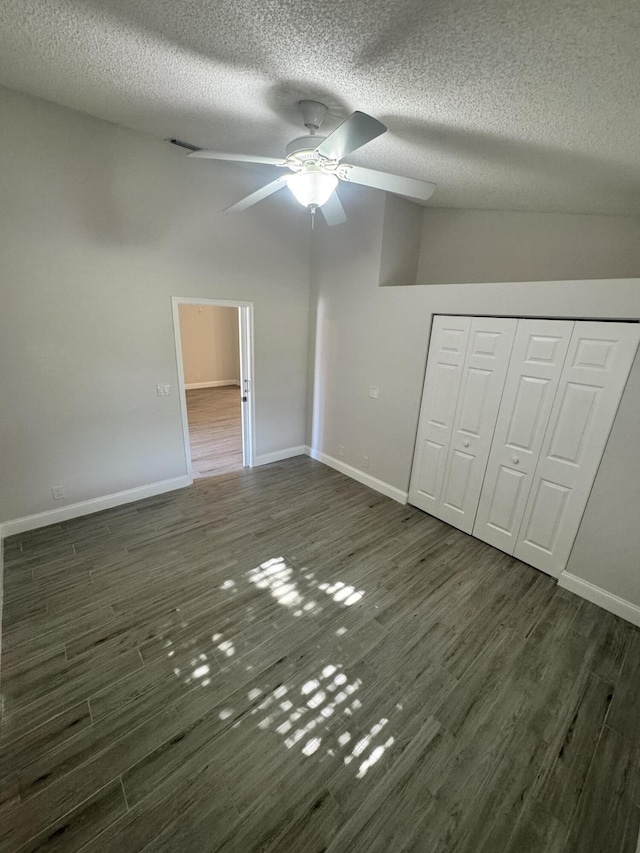 unfurnished bedroom featuring a textured ceiling, ceiling fan, a closet, and dark hardwood / wood-style floors