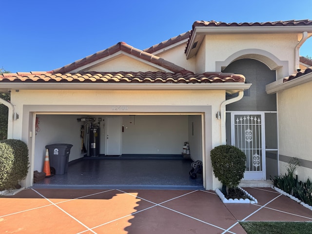 exterior space featuring a garage and electric water heater