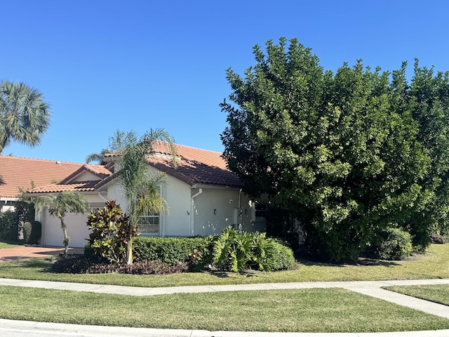 view of side of property with a lawn and a garage