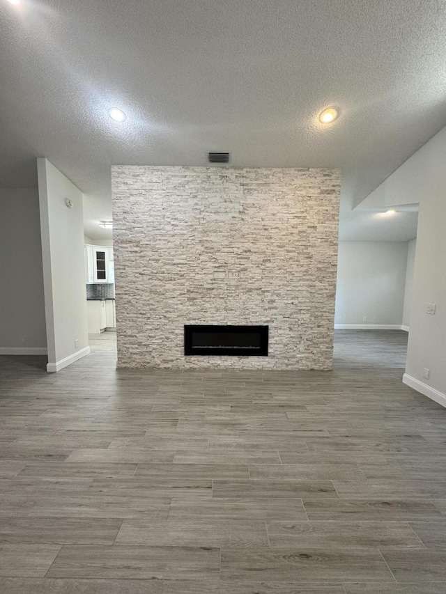 unfurnished living room featuring a fireplace and a textured ceiling