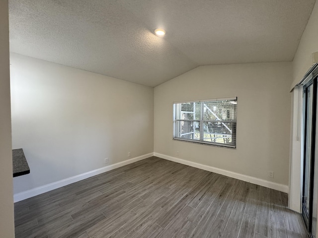 unfurnished room featuring vaulted ceiling and a textured ceiling