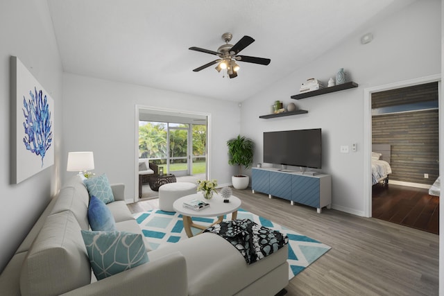 living room with a ceiling fan, lofted ceiling, baseboards, and wood finished floors