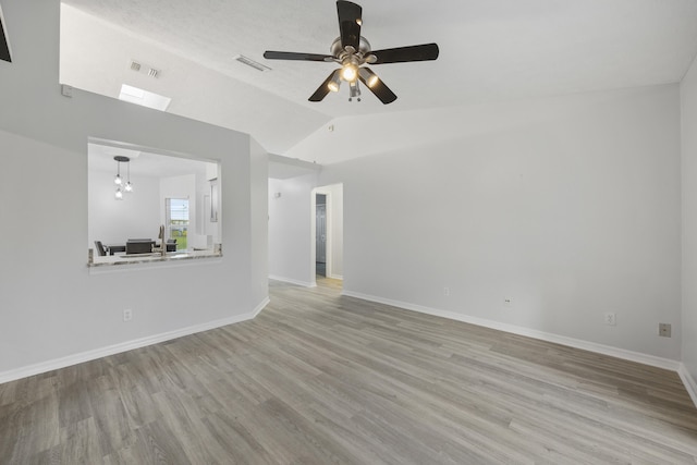 unfurnished living room featuring ceiling fan with notable chandelier, light hardwood / wood-style floors, lofted ceiling, and sink