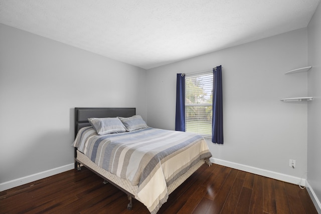 bedroom featuring baseboards, a textured ceiling, and hardwood / wood-style floors