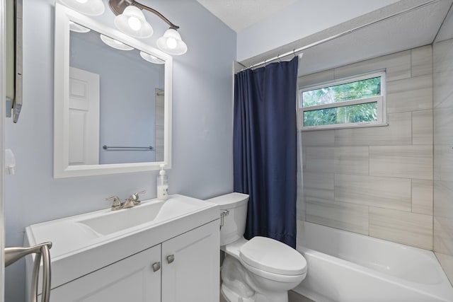 full bathroom with vanity, toilet, shower / bath combo with shower curtain, and a textured ceiling