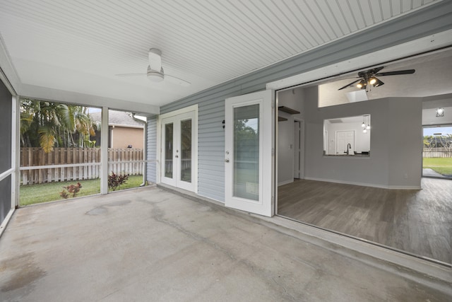 unfurnished sunroom featuring ceiling fan, sink, and french doors