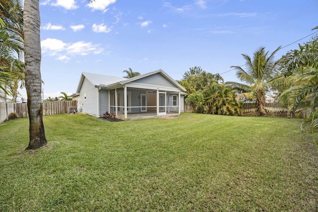 back of property featuring a sunroom, a fenced backyard, and a yard