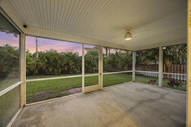 unfurnished sunroom featuring ceiling fan and plenty of natural light