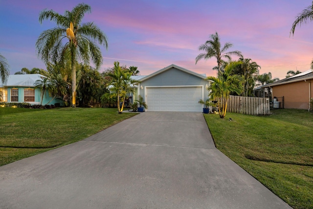 ranch-style home with a garage, fence, a lawn, and concrete driveway