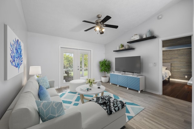 living area featuring lofted ceiling, french doors, wood finished floors, and baseboards